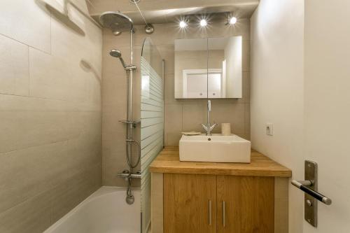 La salle de bains est pourvue d'un lavabo, d'une douche et d'une baignoire. dans l'établissement Apartment Grepon 2, à Chamonix-Mont-Blanc