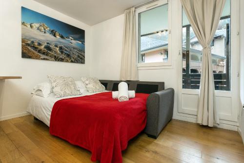 une chambre avec un lit avec une couverture rouge dans l'établissement Apartment Grepon 2 - A Chamonix Alpine Haven, à Chamonix-Mont-Blanc