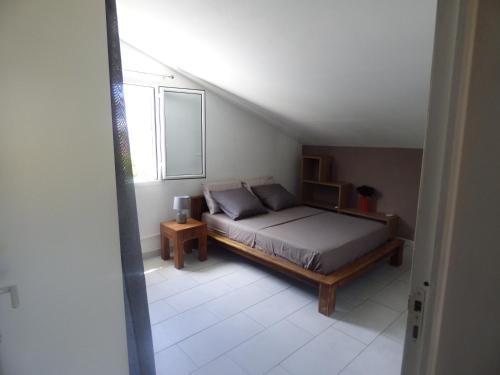- une chambre avec un lit et une fenêtre dans l'établissement Bel appartement spacieux, à Étang-Salé les Bains