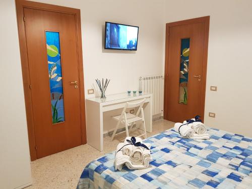 a bedroom with two beds and a desk and a tv at Barone Blu in Salerno