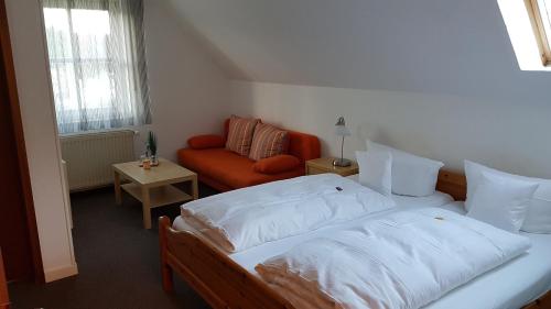 a bedroom with two beds and a couch at Stadthotel am Bühnenhaus in Kevelaer