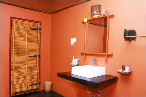 a bathroom with a sink and a mirror at Yala Peace Cottages in Tissamaharama