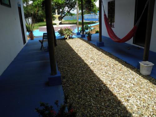 a shady walkway with a hammock next to a house at Hotel campestre la Maria in Villavicencio