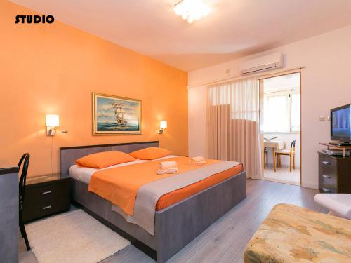 a bedroom with a large bed and a television at Apartments Nives in Poreč