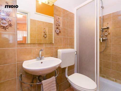 ein Bad mit einem WC, einem Waschbecken und einer Dusche in der Unterkunft Apartments Nives in Poreč