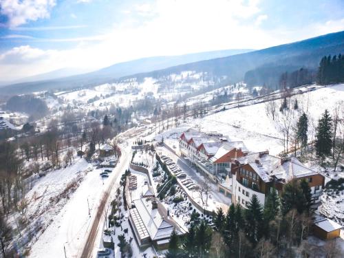 a snow covered mountain with a train station with snow at Hotel & Medi-Spa Biały Kamień in Świeradów-Zdrój
