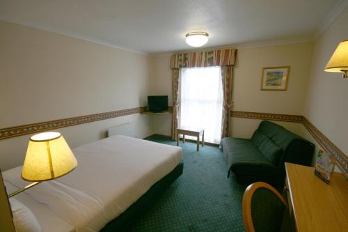 a hotel room with a bed and a couch at Days Inn Hotel Leicester in Leicester