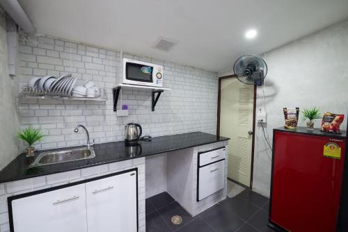 kuchnia ze zlewem i czerwoną lodówką w obiekcie Mein Haus @Bangpo w mieście Bangkok