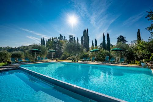 una piscina con sedie blu e ombrelloni di Torraccia di Chiusi Agriturismo Relais a San Gimignano