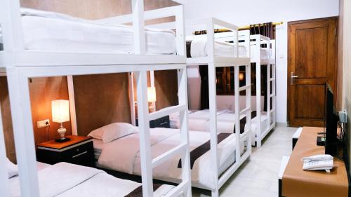 two bunk beds in a room with a desk at BeOne House Jogja in Yogyakarta