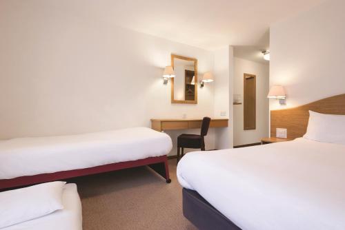 a hotel room with two beds and a desk at Days Inn by Wyndham Telford Ironbridge in Telford