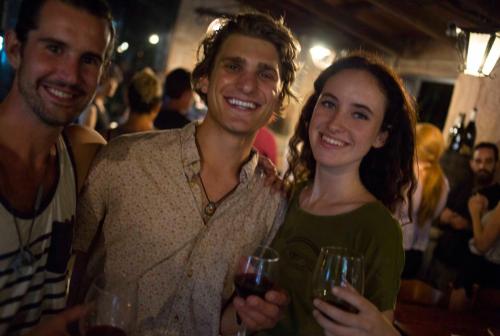 two men and a woman holding glasses of wine at Wiki Hostel Colive in Zagarolo