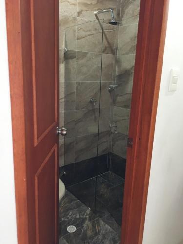 a bathroom with a shower with a glass door at Hotel campestre la Maria in Villavicencio