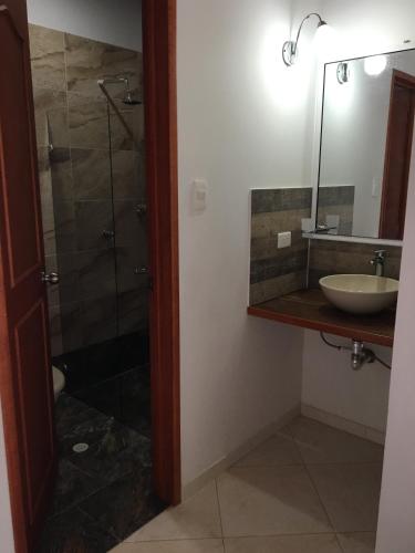 a bathroom with a sink and a shower with a mirror at Hotel campestre la Maria in Villavicencio