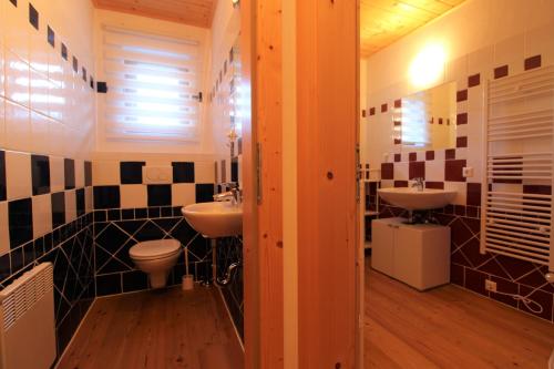 a bathroom with two sinks and two toilets at GRIASS EICH Ski-to-door Apartment by Isa Badkleinkirchheim in Bad Kleinkirchheim