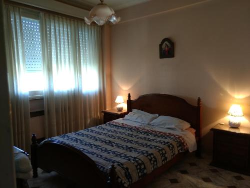a bedroom with a bed and two lamps and a window at Hispano in Mar del Plata