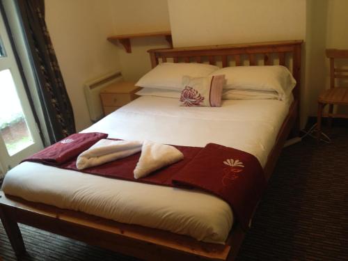 a bedroom with two beds with towels on them at Sandpiper Guest House in Brighton & Hove