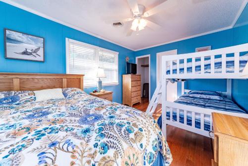 a bedroom with blue walls and a bunk bed at Landing Pad in Kill Devil Hills