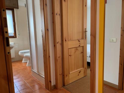 a bathroom with a toilet and wooden cabinets at Trentino Apartments - Casa Aurora in Folgaria
