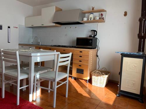 a kitchen with a table and chairs and a microwave at Trentino Apartments - Casa Aurora in Folgaria