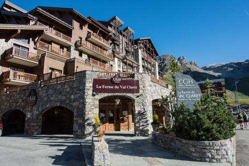 un bâtiment dans les montagnes avec un panneau sur celui-ci dans l'établissement CGH Résidences & Spas La Ferme Du Val Claret, à Tignes