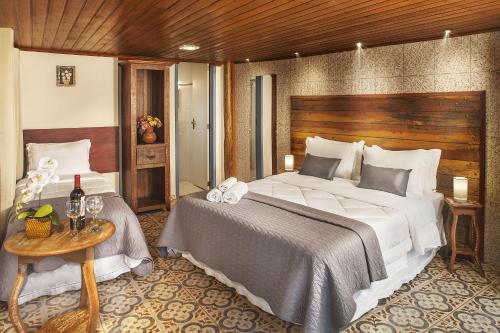 a bedroom with a large bed and a table at Pousada Makutta in Lavras Novas