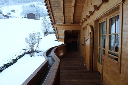 フューゲンベルクにあるFerienwohnung Claudiaの冬の景色を望むログキャビンの玄関