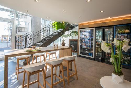 a restaurant with a bar with stools and a staircase at ibis budget Nice Californie Lenval in Nice