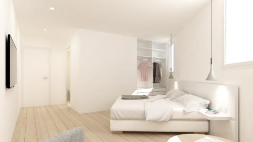 a white bedroom with a white bed and a window at Hotel hcp in Calella de Palafrugell