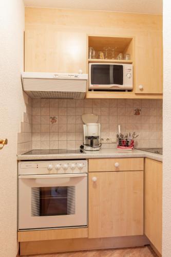 a kitchen with a stove and a microwave at Haus Saskia in Sölden