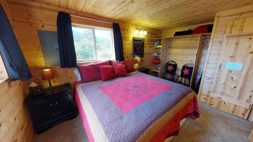 sypialnia z łóżkiem w drewnianym domku w obiekcie White Pine Cabin by Canyonlands Lodging w mieście Monticello
