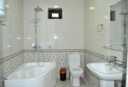 y baño con bañera, aseo y lavamanos. en HOtel Like, en Samarkand
