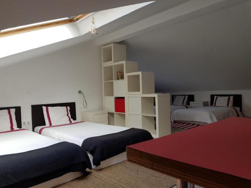 a bedroom with two beds and a red table at Casas Do Contrabando in Marvão