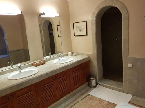 a bathroom with two sinks and two mirrors at Palais Claudio Bravo in Taroudant