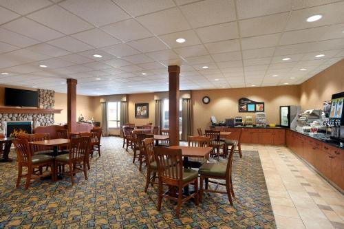 a dining room with wooden tables and chairs at Days Inn & Suites by Wyndham Strathmore in Strathmore