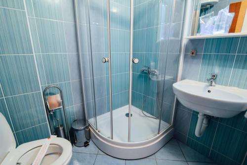 a bathroom with a shower and a sink and a toilet at Hotel Mod in Sarajevo