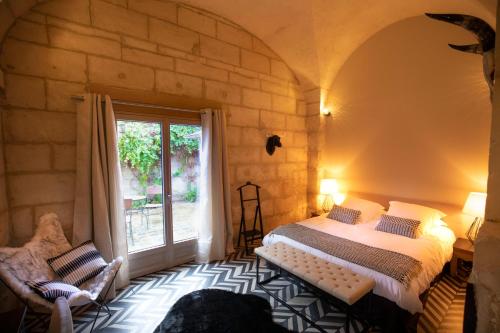 a bedroom with a bed and a large window at Le Baptistère - Adults only in Attichy