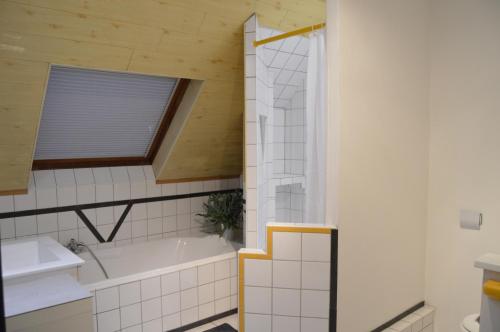 La salle de bains est pourvue d'une baignoire et d'un lavabo. dans l'établissement Au Pays de la Potasse, à Ungersheim