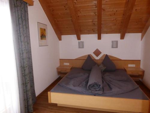 Bett in einem Zimmer mit Holzdecke in der Unterkunft Apart Alba in Ischgl