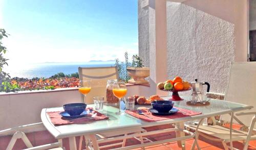 una mesa con comida y bebida en el balcón en Breathtaking Costabrava seaview apartment 5m beach - Casa ArteVida en Rosas
