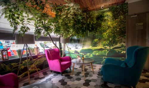 a room with chairs and a table and a painting at Auto Port Renice in Myślibórz