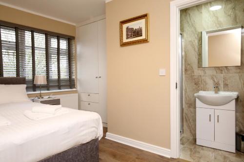 a bedroom with a bed and a sink and a mirror at Oxford City Boutique Home: "Oxford Collegiate Residence by AHG" in Oxford