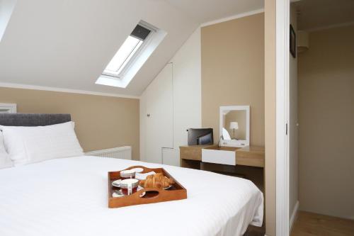 a bedroom with a bed with a tray with a cat on it at Oxford City Boutique Home: "Oxford Collegiate Residence by AHG" in Oxford