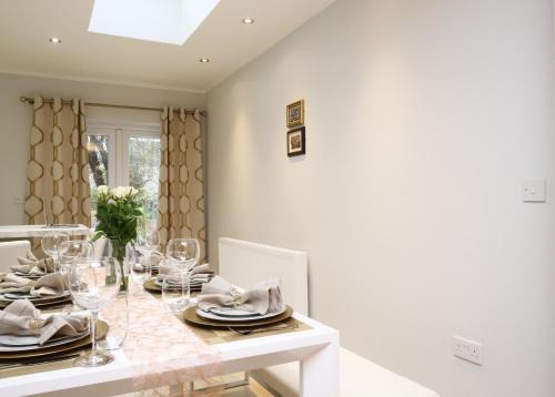 a dining room with a table with plates and glasses at Oxford Collegiate Serviced Residence by AHG in Oxford