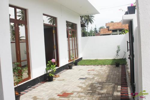 a white house with windows and a courtyard at Ever Green Villa in Negombo