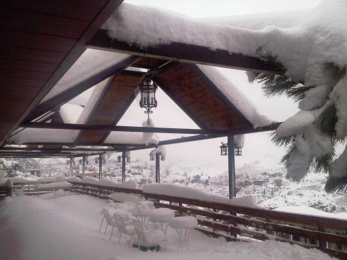 a room covered in snow with tables and chairs at Hotel Chbat in Bcharré