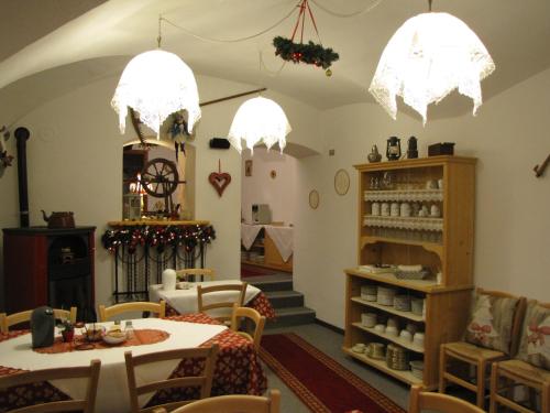 a restaurant with tables and chairs and chandeliers at La Molinela B&B in Folgaria