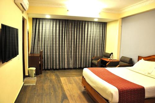 a hotel room with a bed and a chair at Tibet Guest House in Kathmandu