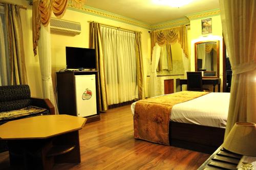 Habitación de hotel con cama y sala de estar. en Tibet Guest House, en Katmandú