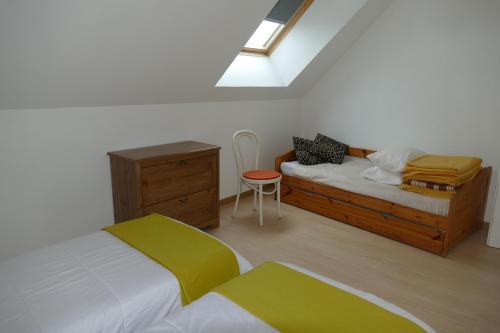 a bedroom with a bed and a dresser and a bed and a chair at la ferme du parroi in Annecy